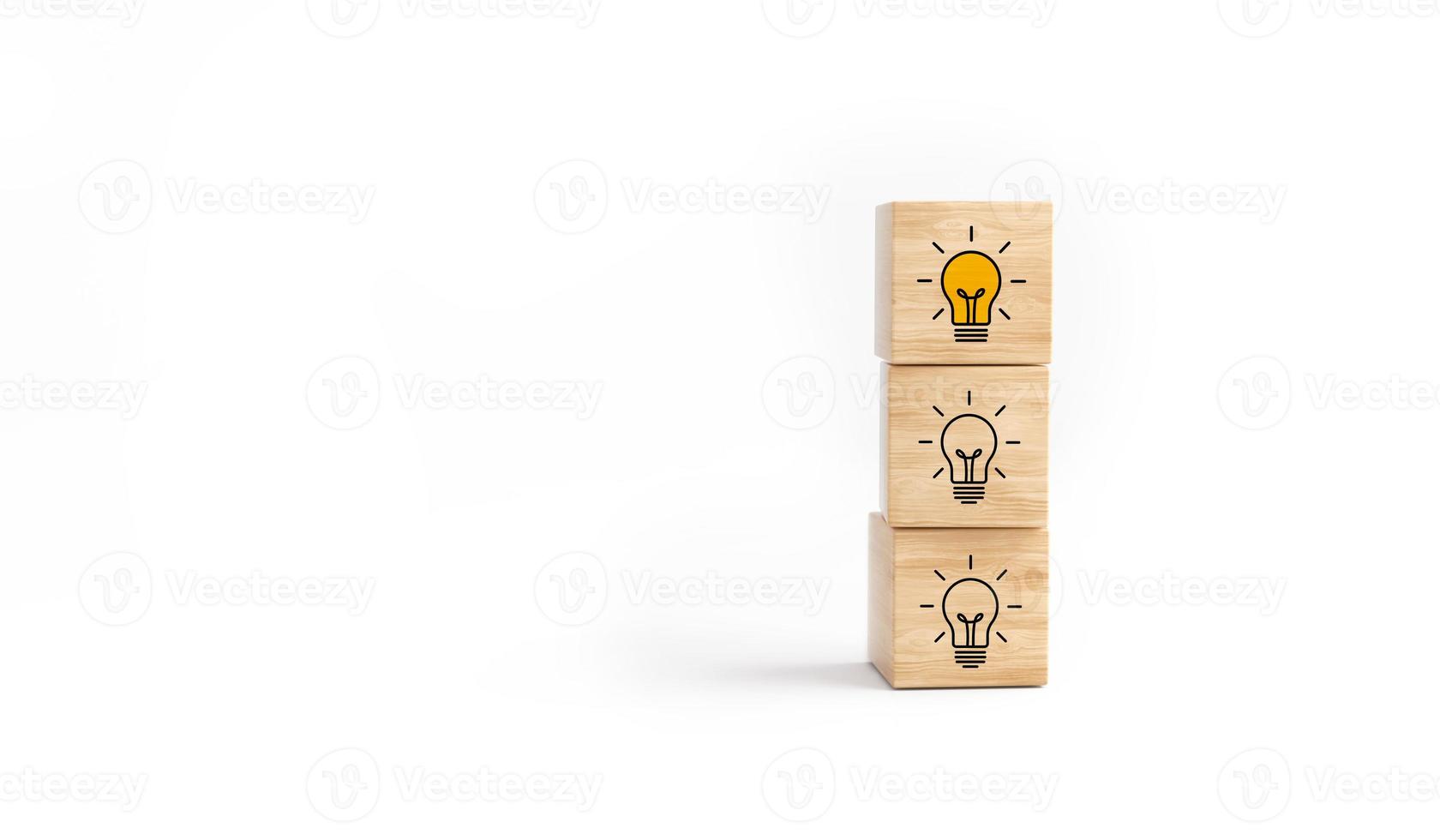 Wooden cube block tower with light bulb icon on white background. photo