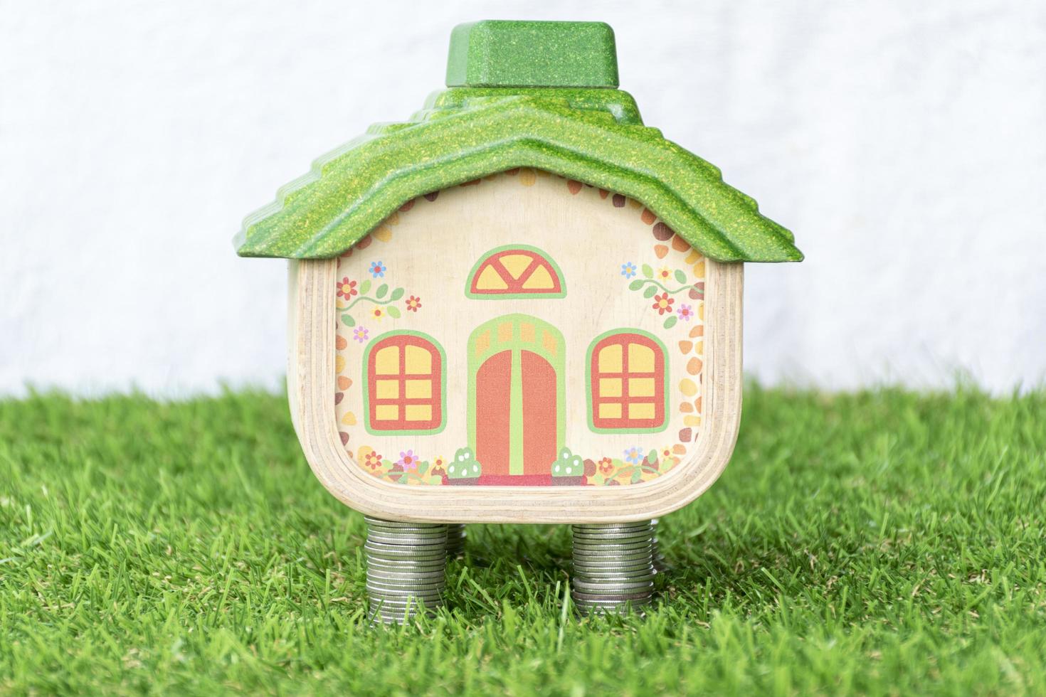 Mock up house on coins stack and grass floor photo