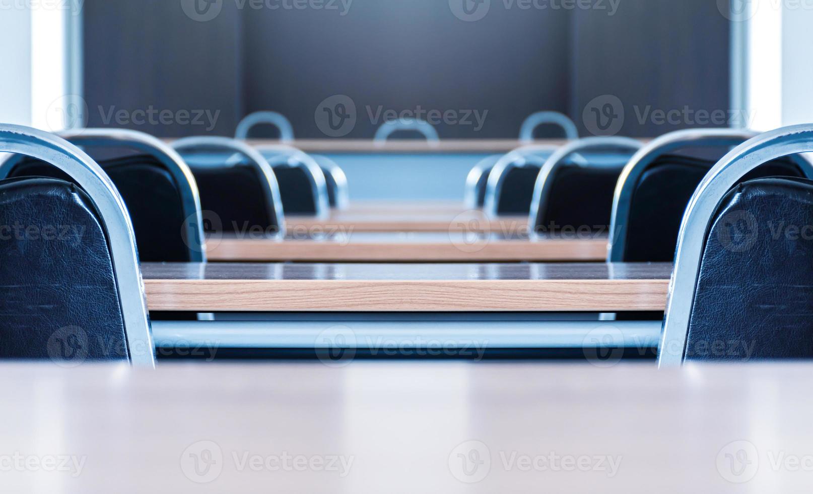 Close up the chair in in seminar room with a speaker table in the middle of the stage photo