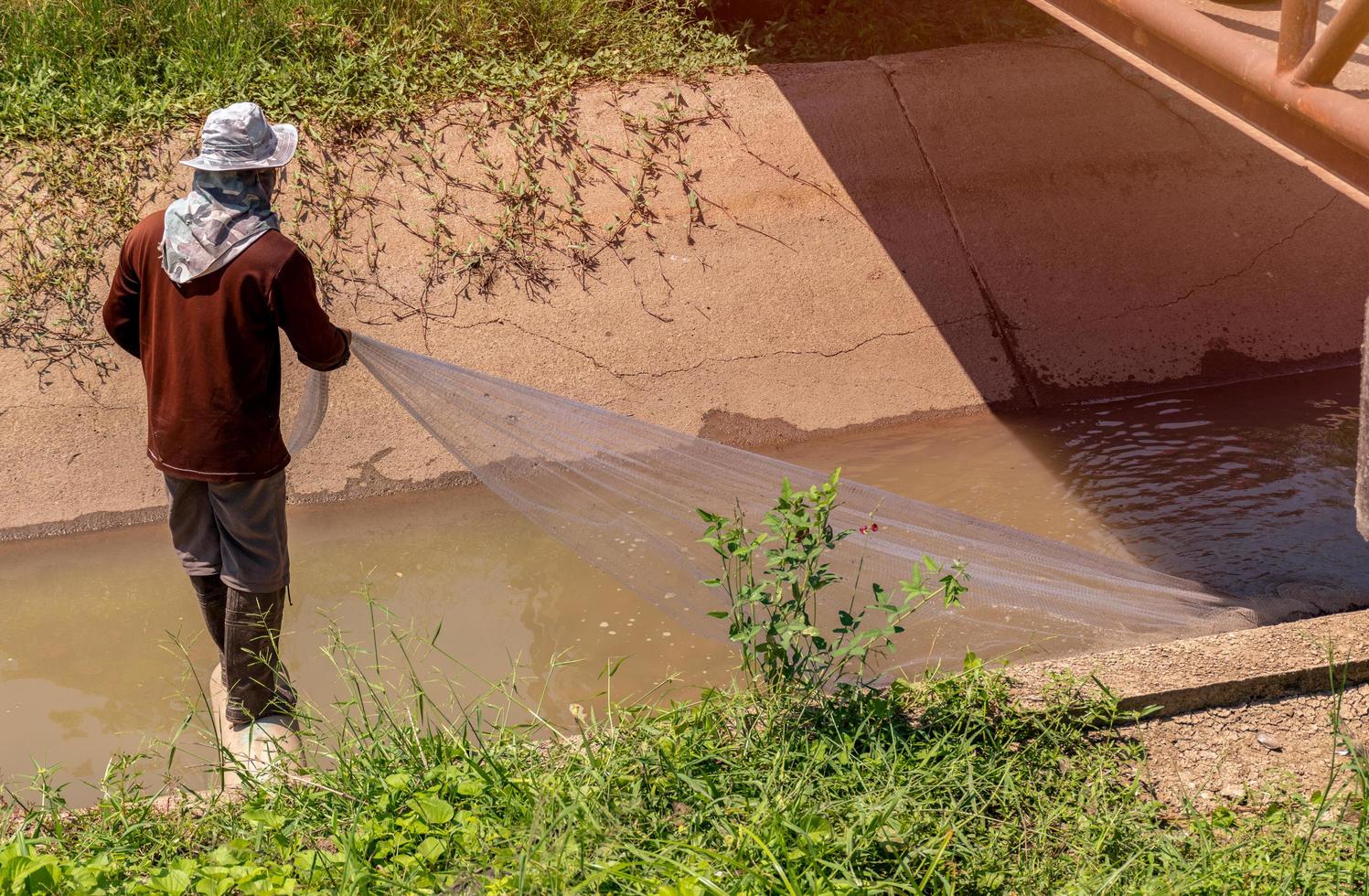 Villagers are catching fish along the canal photo