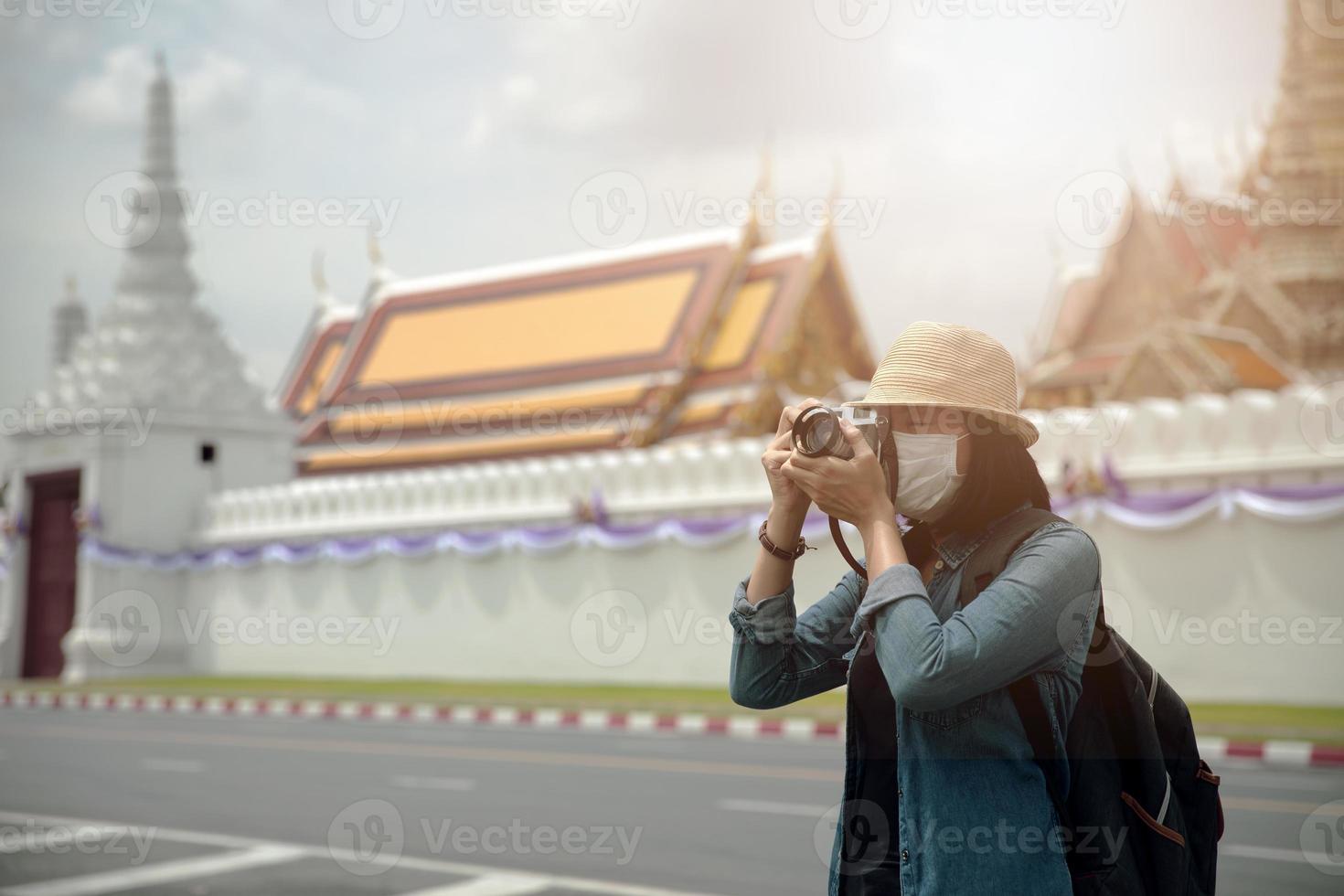 Asian women wearing surgical face mask traveler with camera travel of lifestyle portrait , outdoor summer concept photo