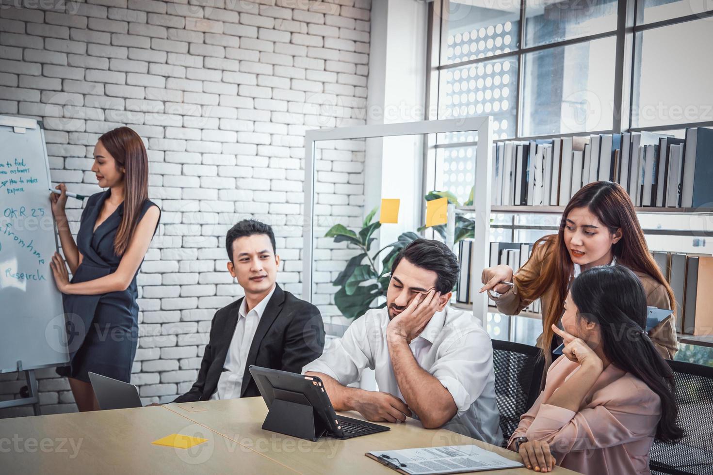 hombre de negocios cansado durmiendo en una conferencia de reunión en la oficina, gente del equipo de negocios mirando severamente los ronquidos en la reunión foto