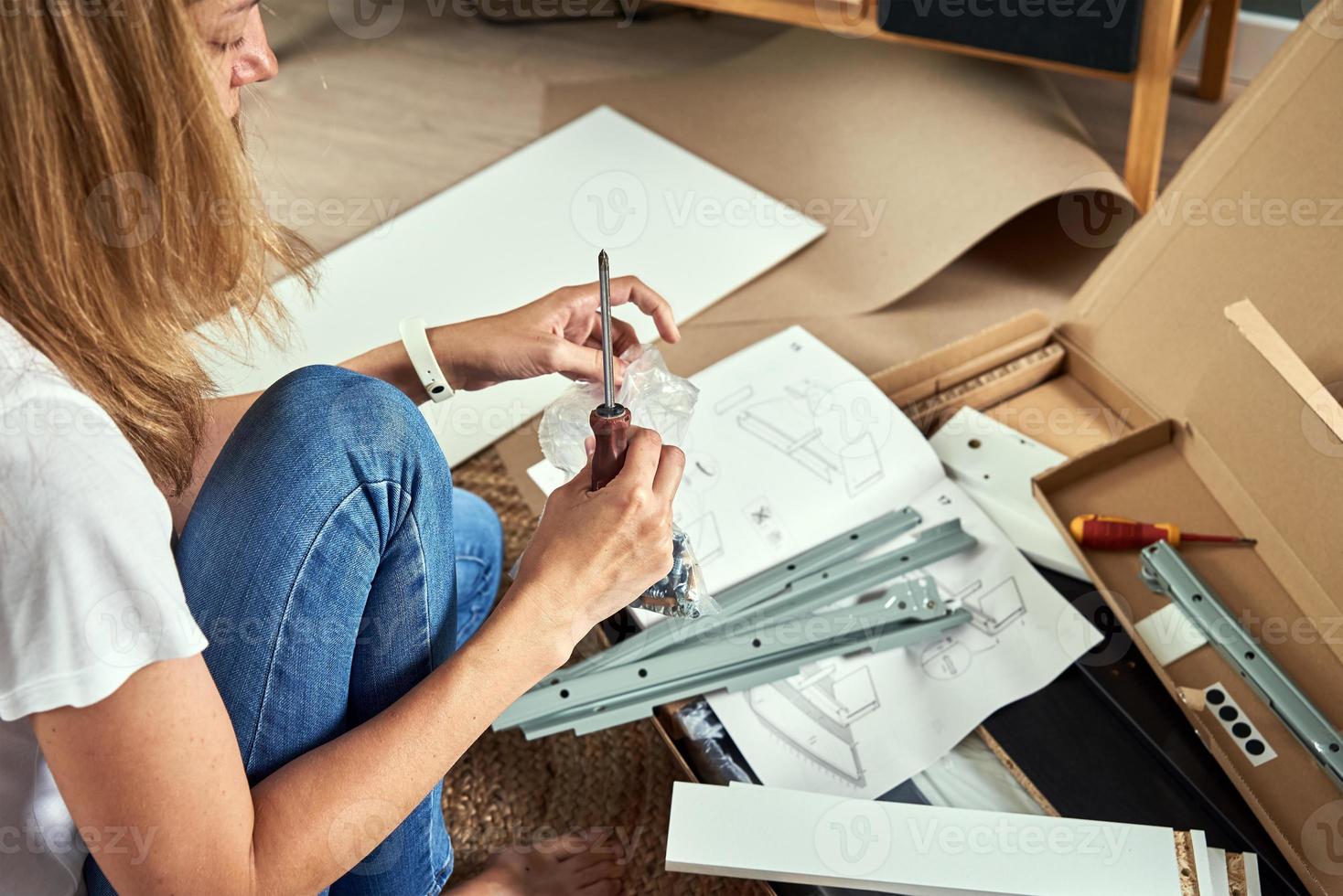 Woman reading manual instruction to assemble furniture photo