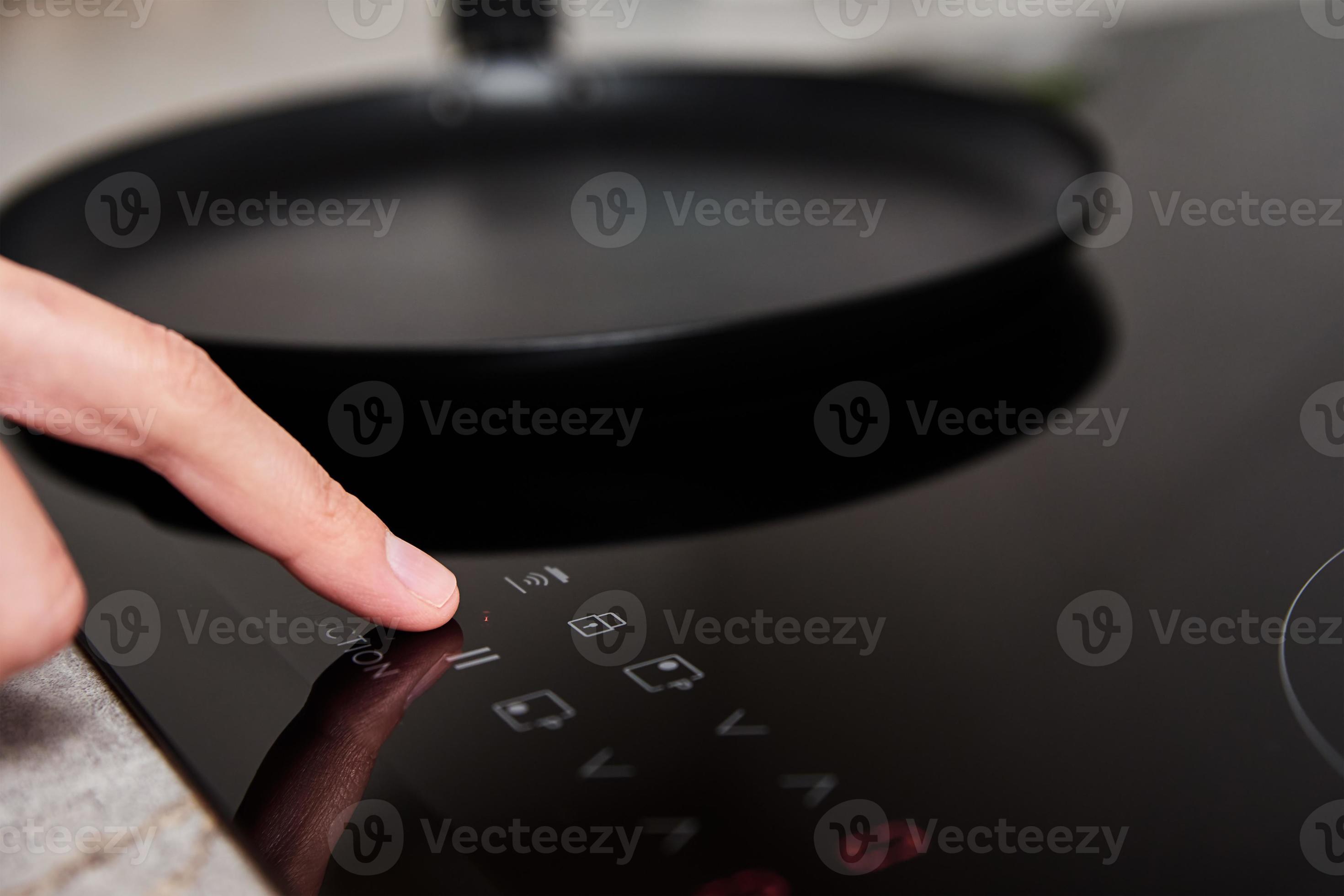 Woman hand turns on modern induction stove in the kitchen 17526938