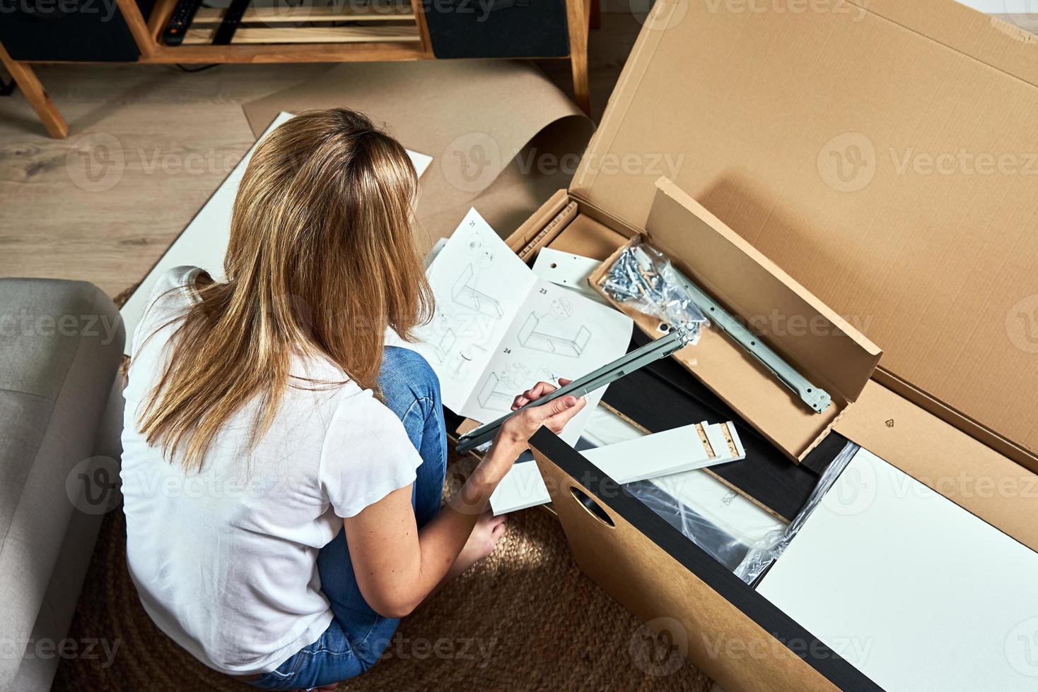 mujer leyendo manual de instrucciones para montar muebles foto