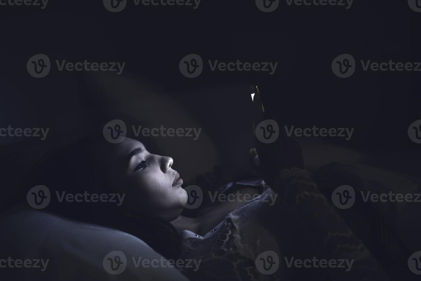 Asian woman play smartphone in the bed at night,Thailand people photo