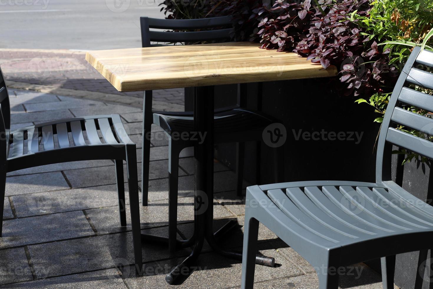 Chair and table in a cafe in a city park near the sea. photo