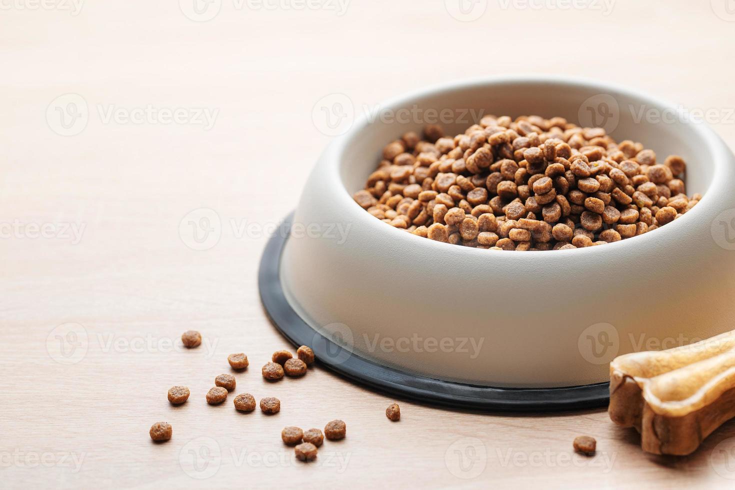 A bowl of dog food on a wooden floor. photo