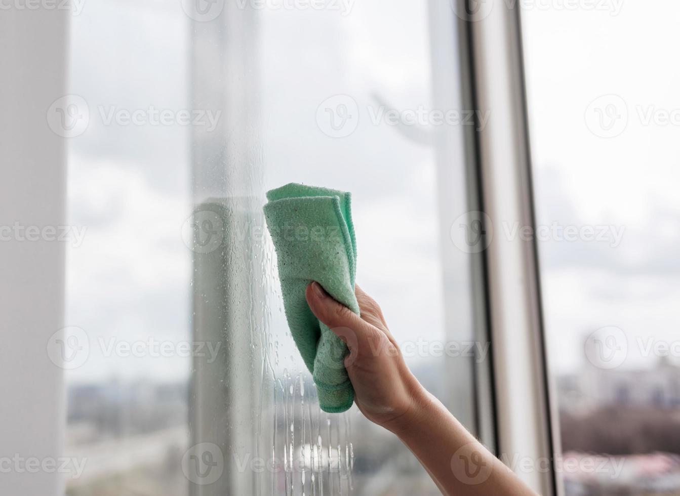 woman cleaning window with rag photo