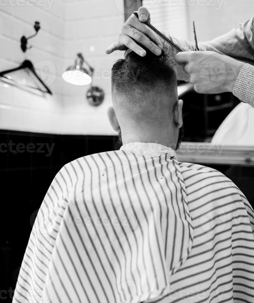 barber cuts the client's scissors photo
