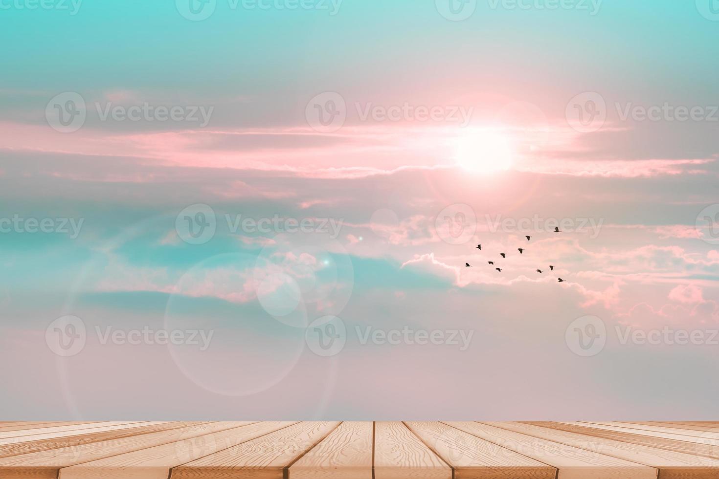 Wood top table and sunrise and flare back horizon sky with pastel blue tone cloud and fog over on the top mountain with birds flying photo
