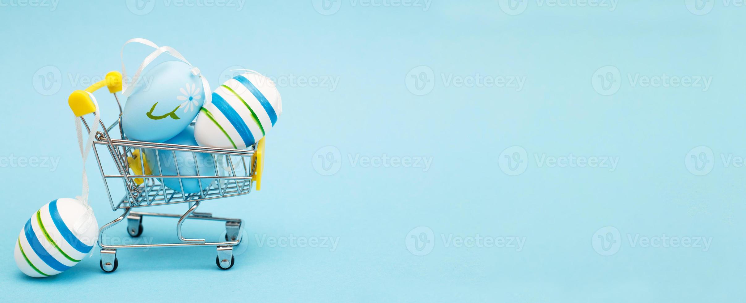 Easter eggs in the shopping cart on a blue background. banner photo
