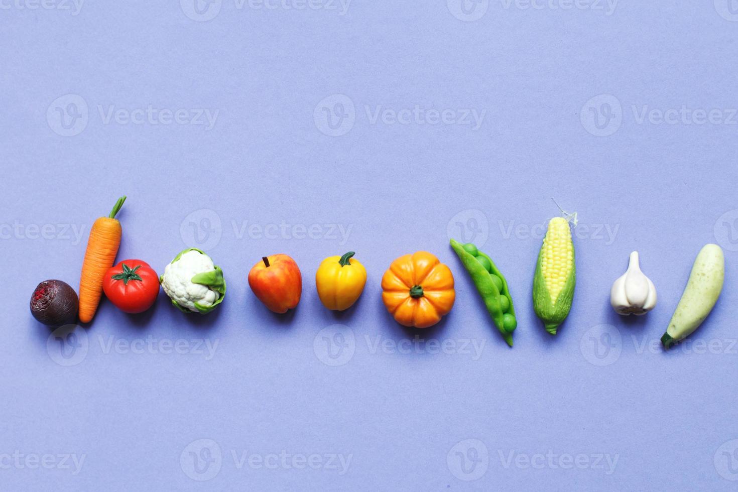 many vegetables and fruits on purple background. healthy food concept photo