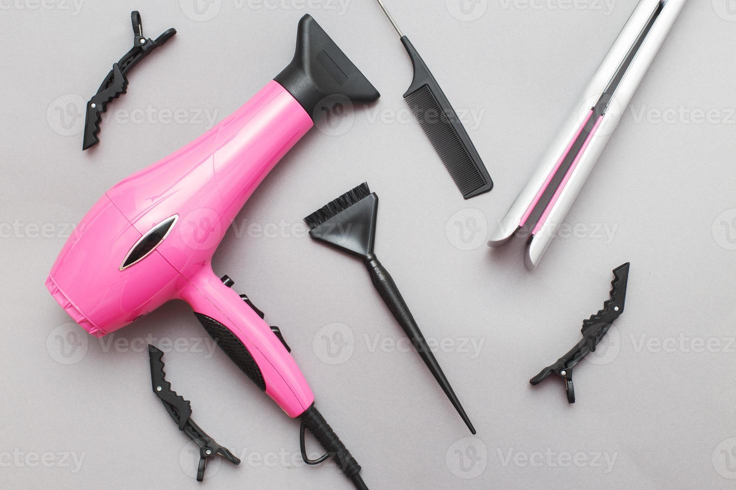 various hairdressing tools like hair dryer, comb on a gray background. beauty salon concept photo