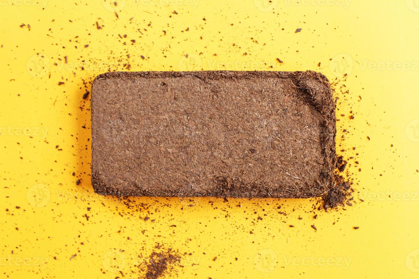 soil texture close up. mock up. coconut briquette on a orange background. photo