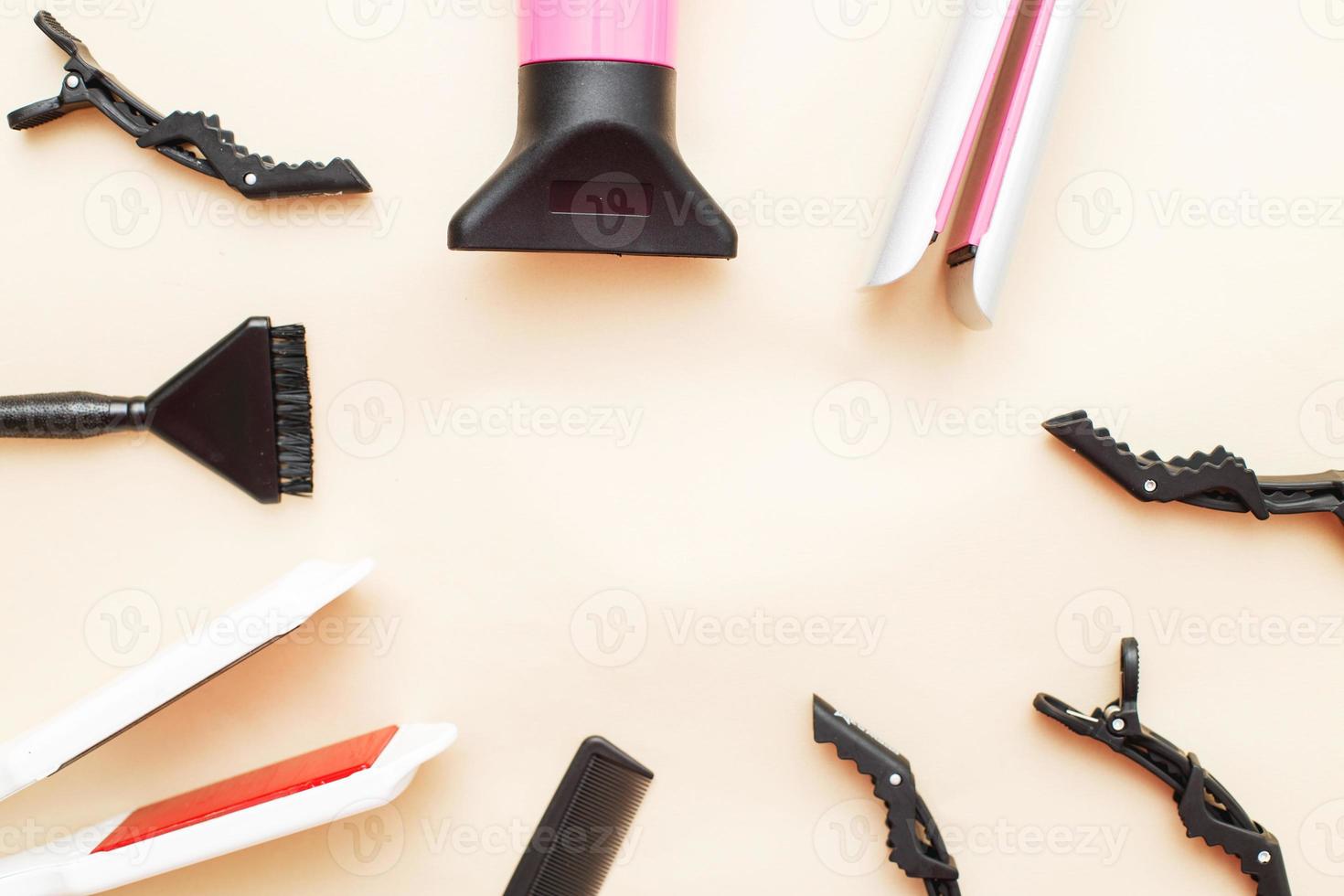 varias herramientas de peluquería como secador de pelo, peine sobre un fondo beige. concepto de salón de belleza foto