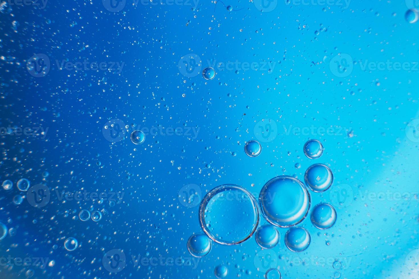 abstract light blue background with oil circles . bubbles of water close up . photo