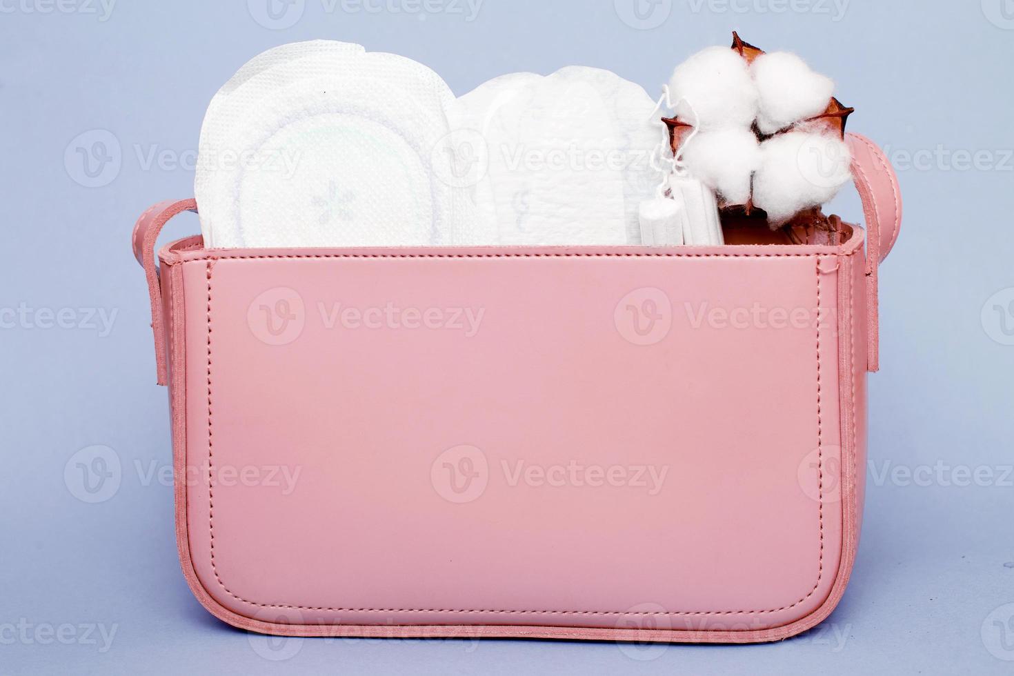 tampones, panty liners higiénicos, toallas sanitarias femeninas en una bolsa cosmética rosa para mujer foto