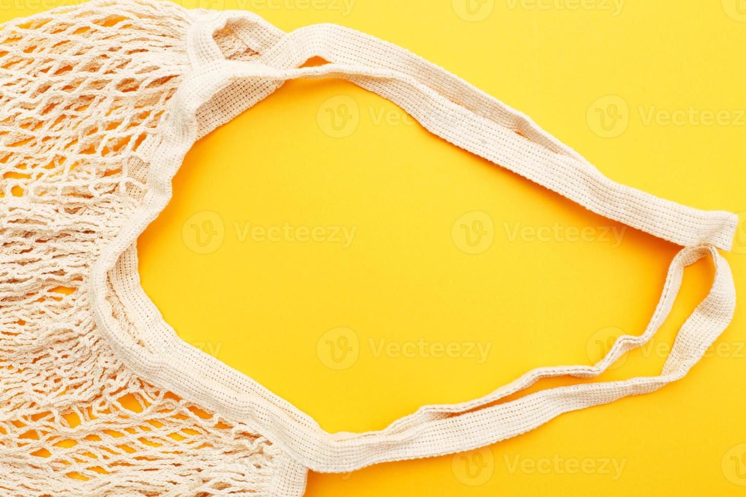 empty beige reusable string shopping bag on orange background. plastic free photo