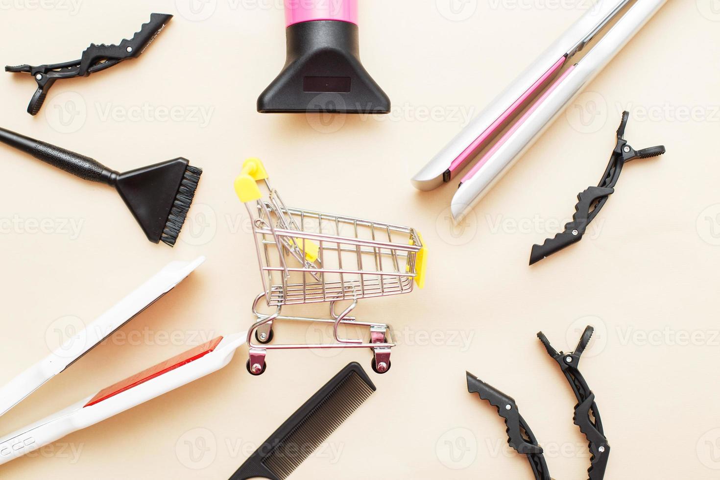 varias herramientas de peluquería con carrito de compras sobre un fondo beige. concepto de salón de belleza foto