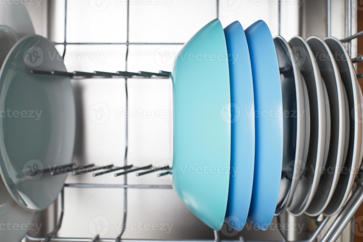 Open dishwasher with clean dishes in the kitchen photo