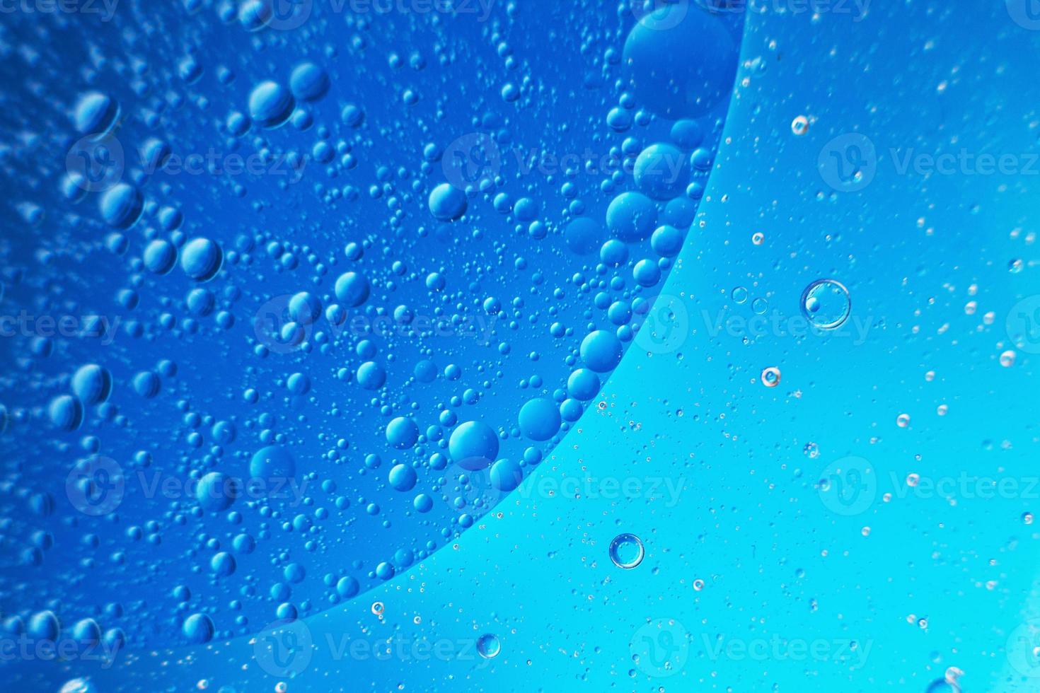 abstract light blue background with oil circles . bubbles of water close up . photo