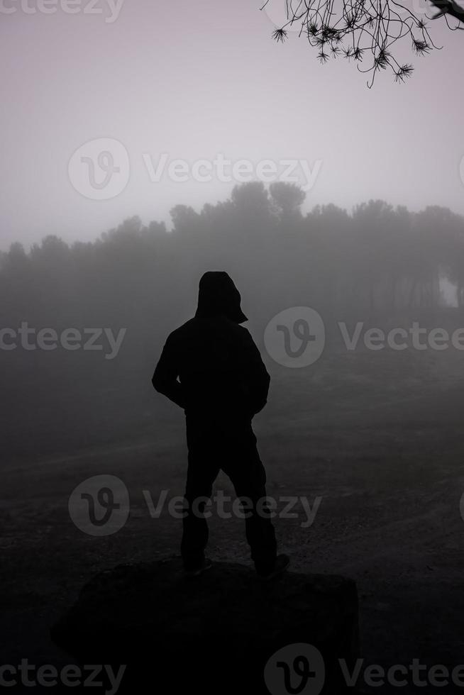 hombre en bosque con niebla foto