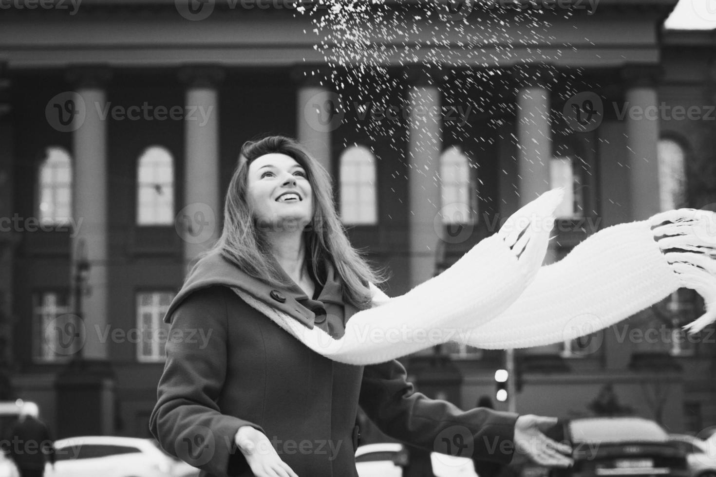 Close up happy lady with long scarf and falling snow monochrome portrait picture photo
