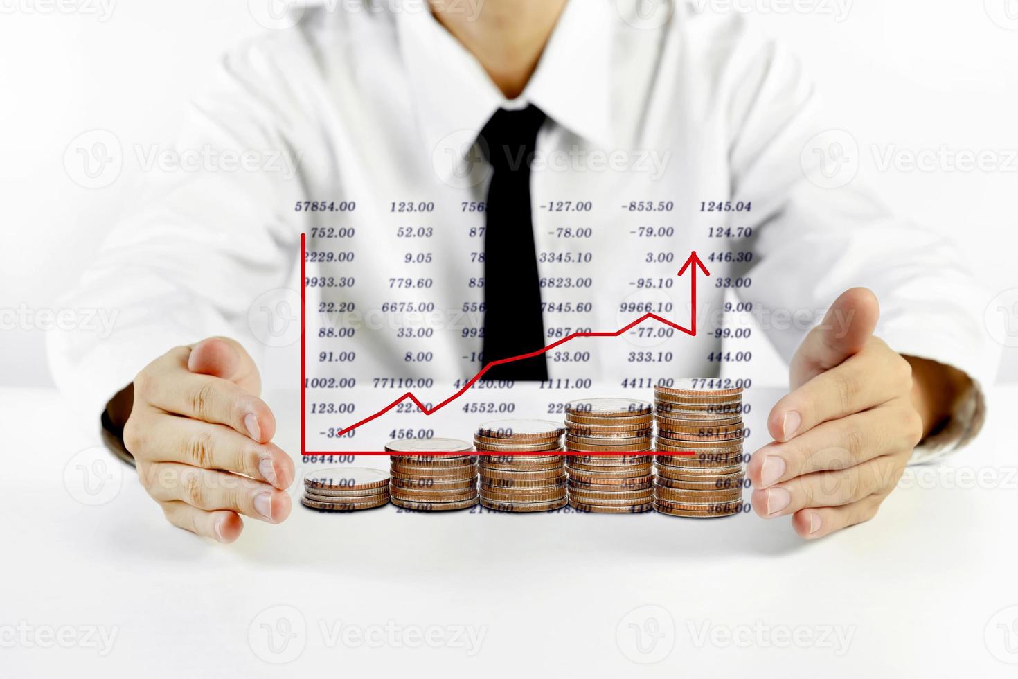 businessman hands protecting piles of coins with chart photo