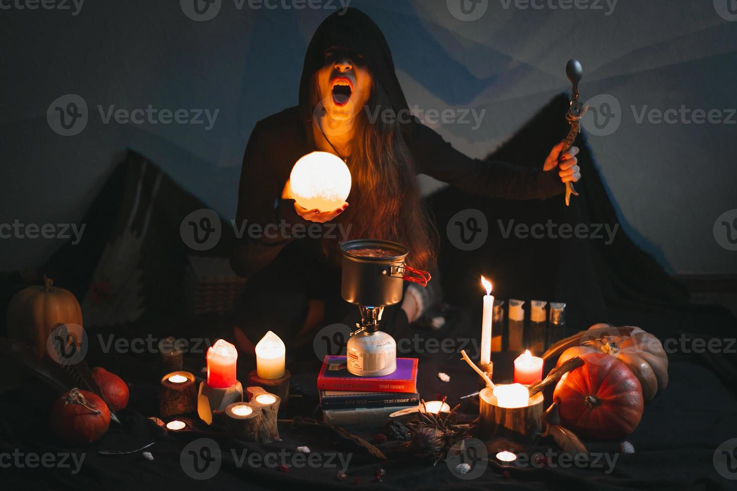 Close up woman casting spell with glowing ball and spoon portrait picture photo