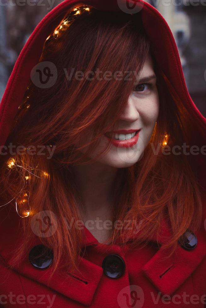 Close up positive redhead woman with hood and lights portrait picture photo