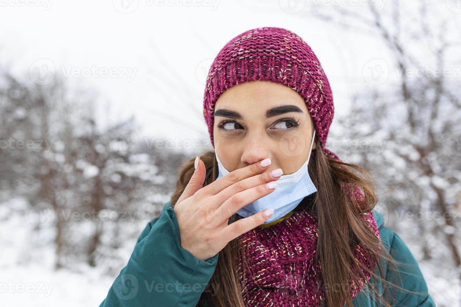 Don't touch your face, stop spreading Coronavirus. Young woman touching her nose with dirty hand. Avoid touching your face. Woman putting down face mask rubbing her nose outdoor. photo