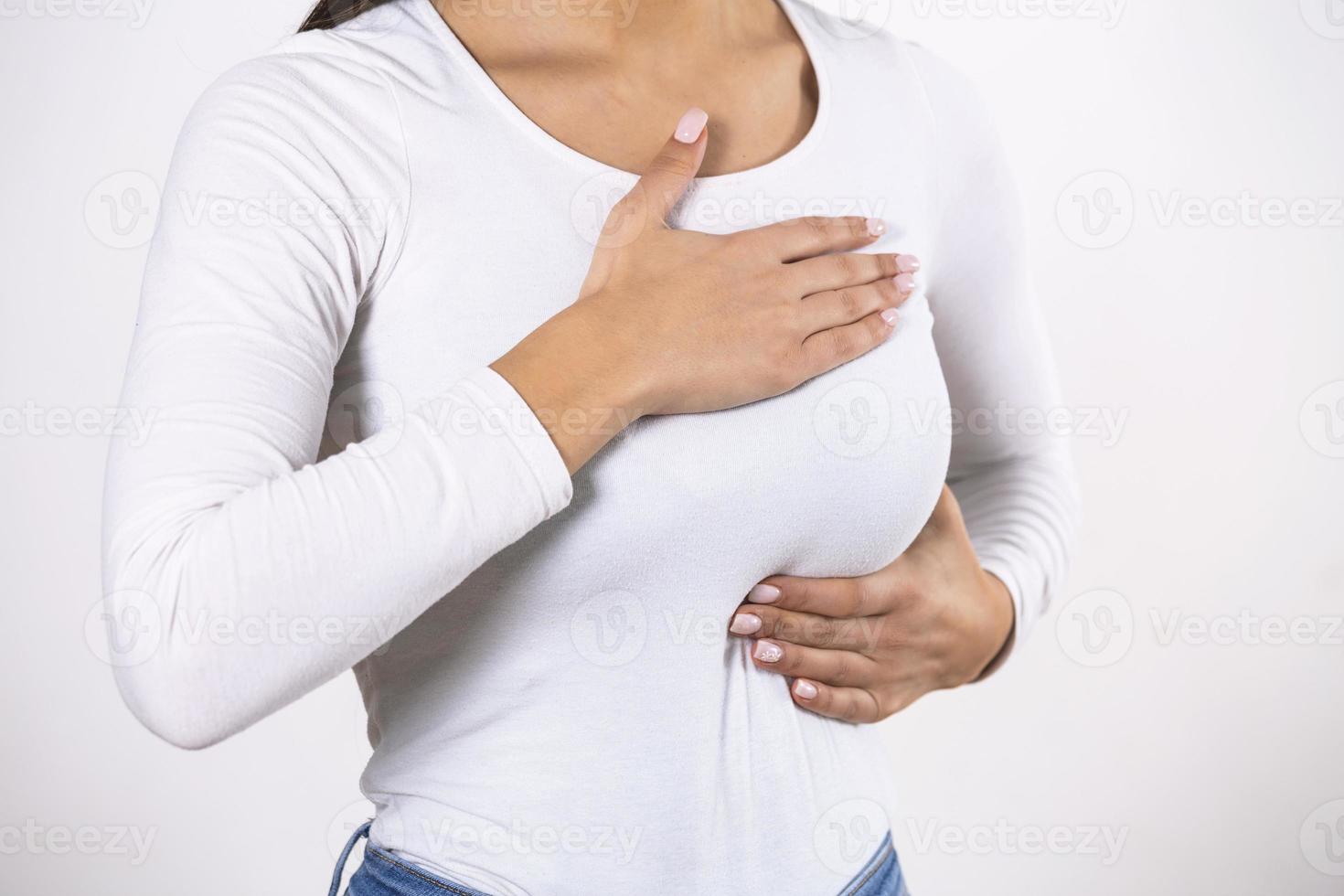 Woman Wearing A White Tank Top Checking Her Breast, Breast Self-Exam, How do I check breast concept, Breast Cancer Awareness, palpation test photo