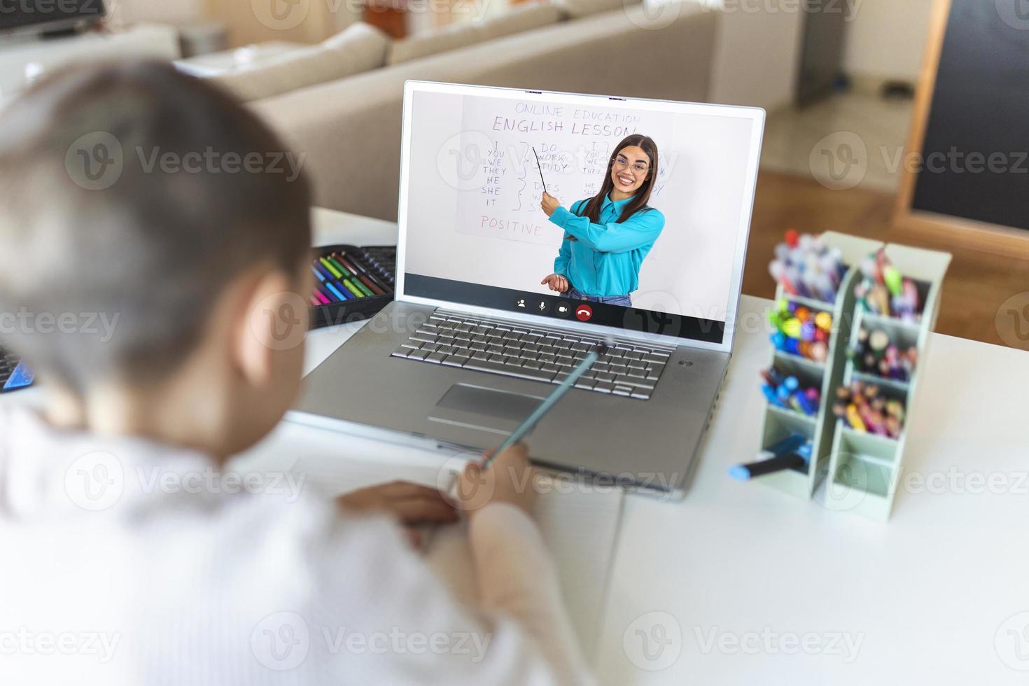 Online remote learning. School kids with computer having video conference chat with teacher and class group. Child studying from home. Homeschooling during quarantine and coronavirus outbreak. photo