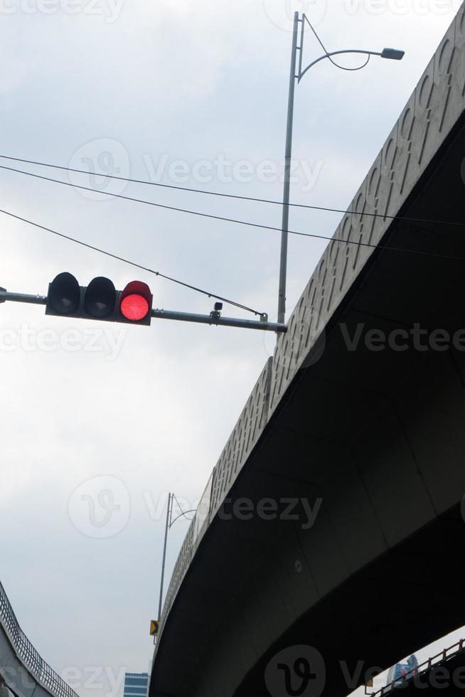 Red color traffic light on the street with sky background photo