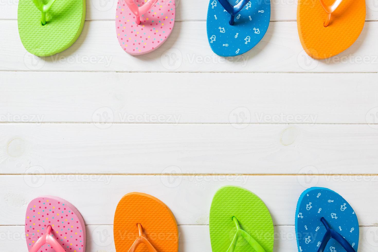 a lot of flip flop colored sandals, summer vacation on wooden background, copy space top view photo