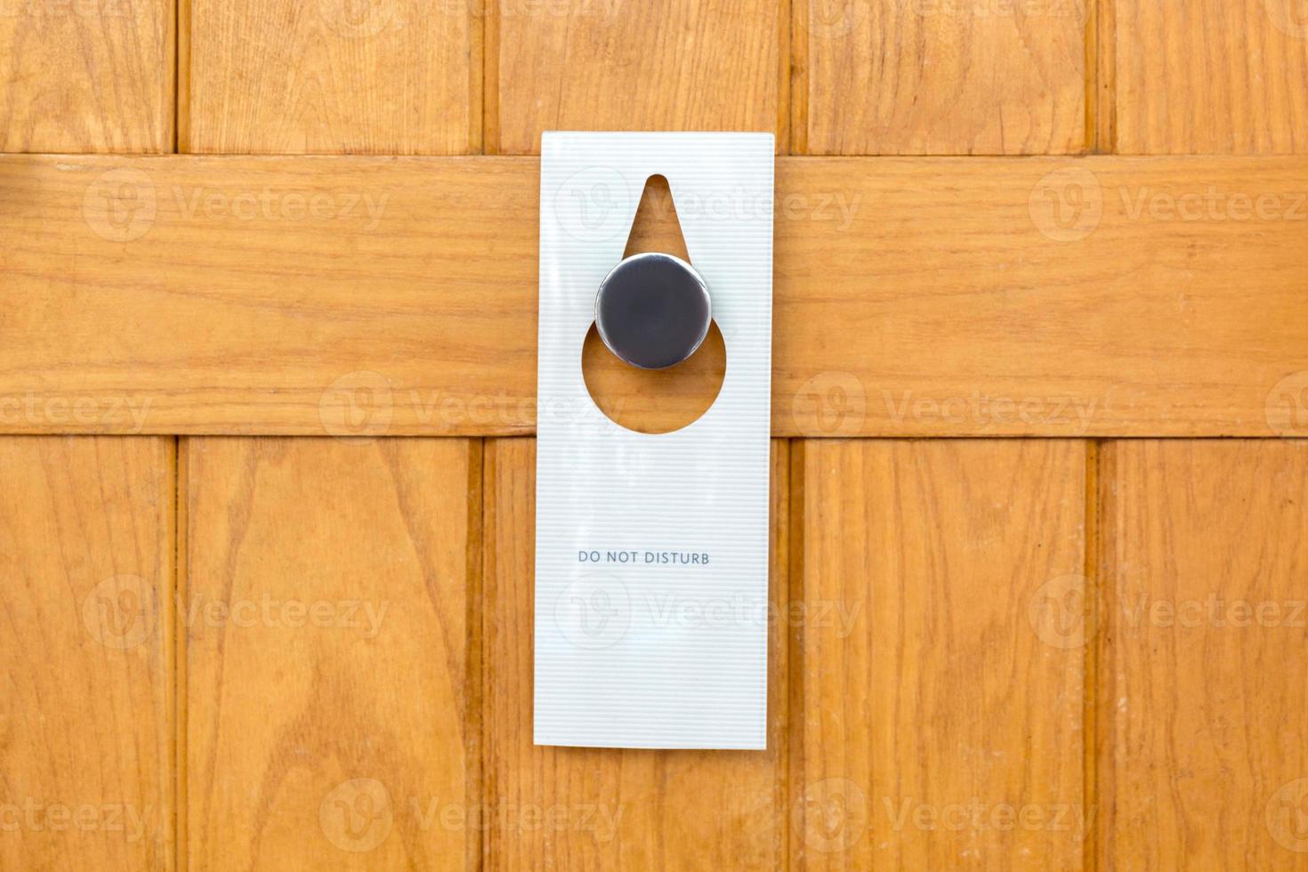 please do not disturb sign on Closed wooden door of hotel room photo