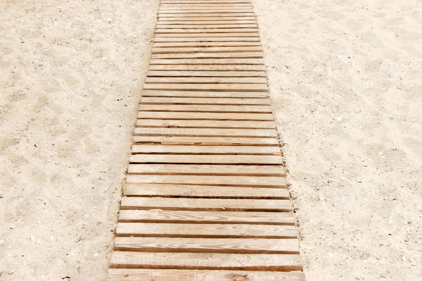 Wooden beach boardwalk with sand for background photo