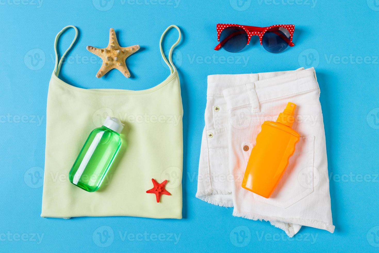 Flat lay composition with Beach accessories on blue color background. Summer holiday background. Vacation and travel items top view photo