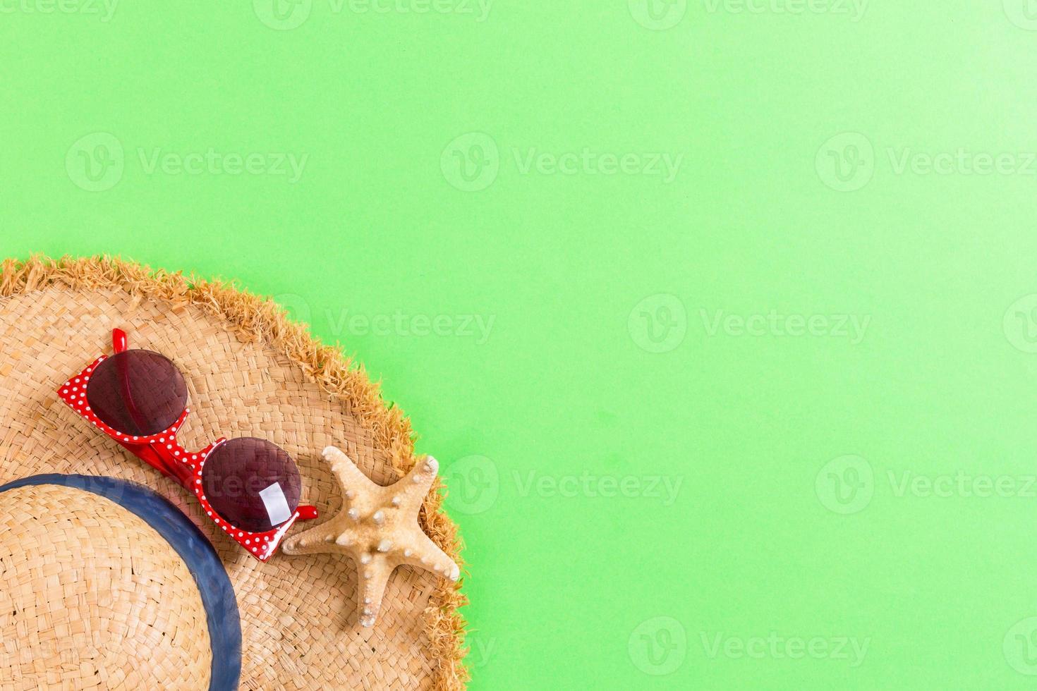 Beach hat with seashells on brown green table. summer background concept with copy space top view photo