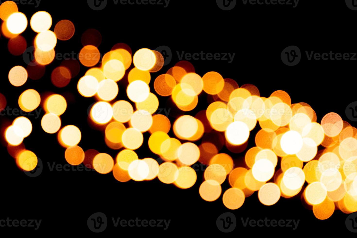 Festive abstract gold background with bokeh defocused and blurred many round yellow light on Christmas dark background photo