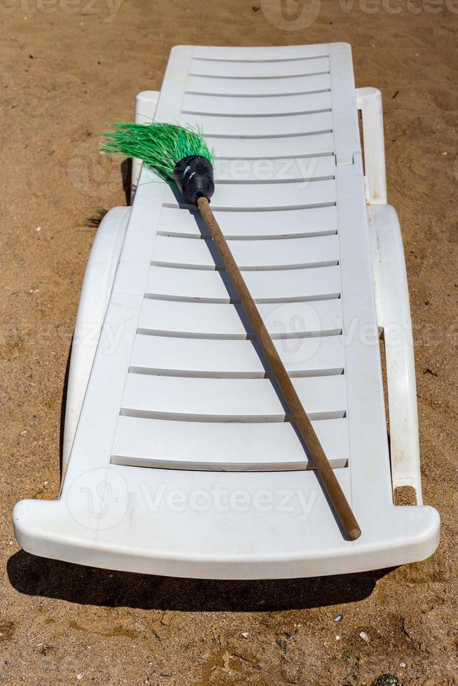 Plastic white sun lounger on the sand beach photo