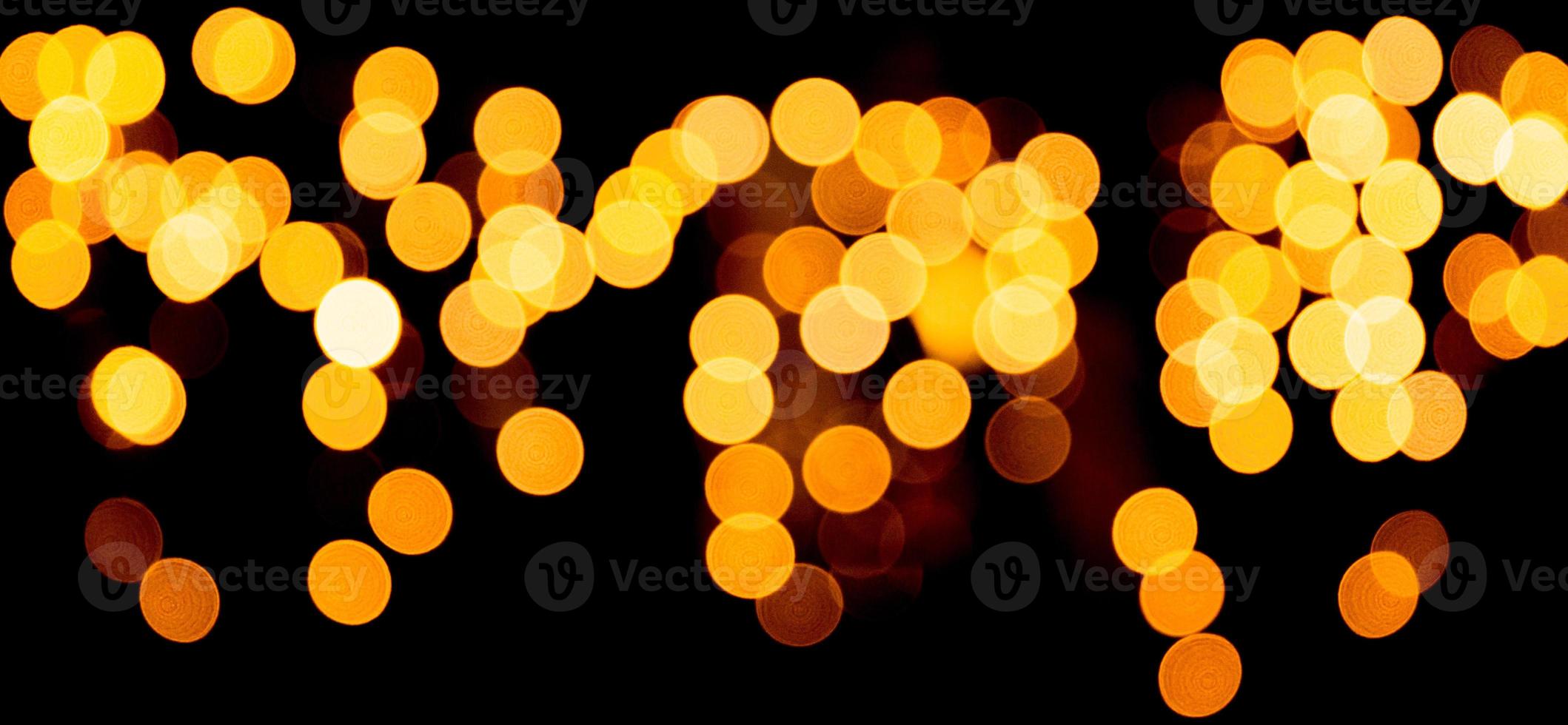 Unfocused abstract gold bokeh on black background. defocused and blurred many round light photo