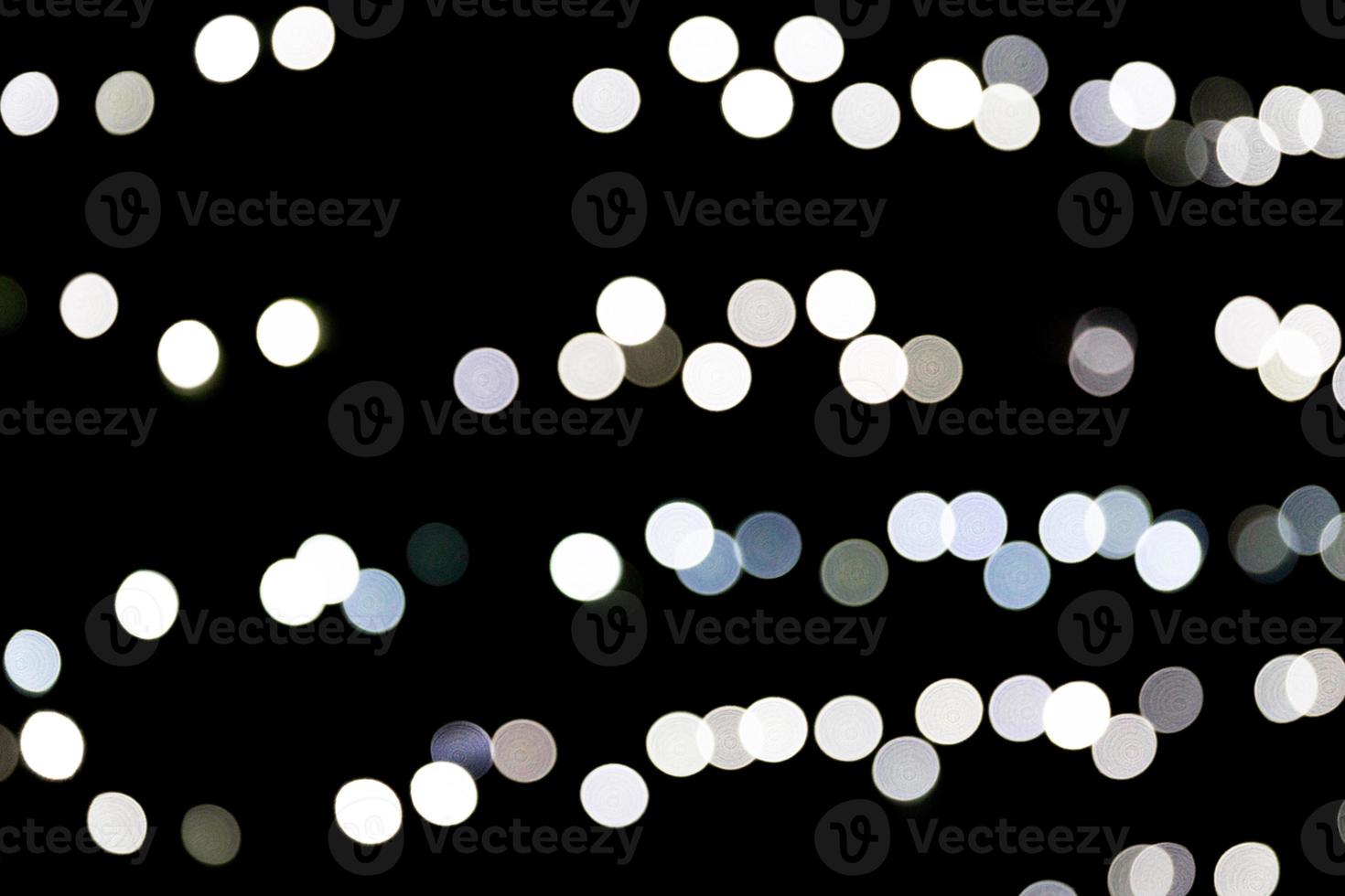 Abstract bokeh of white city lights on black background. defocused and blurred many round light photo
