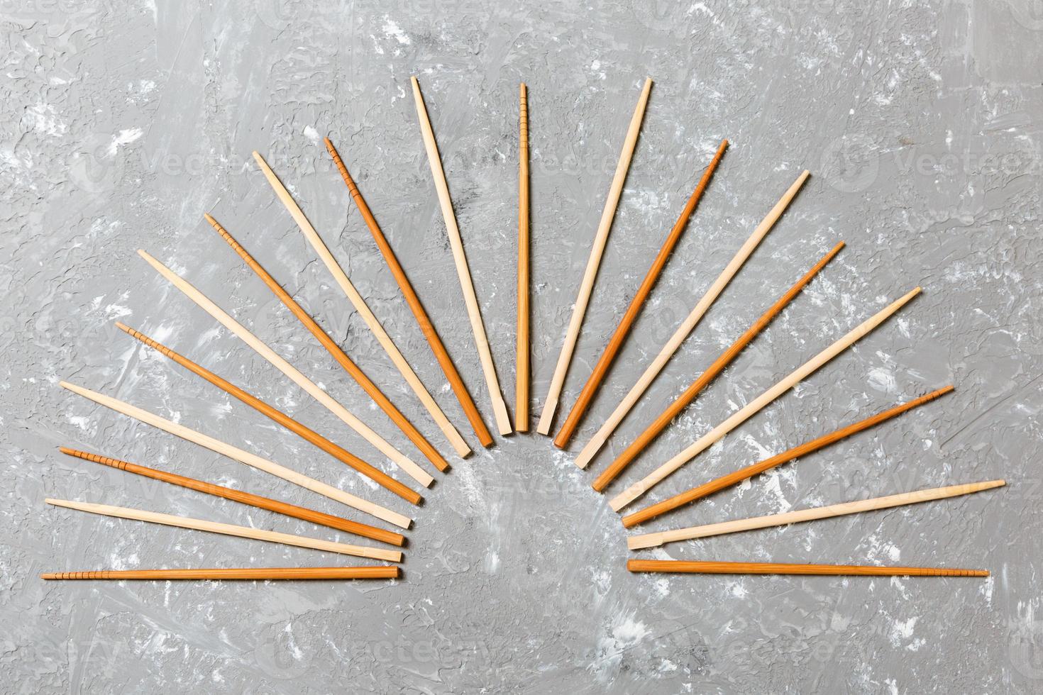 Many bamboo chopsticks on black cement stone background, top view with copy space. a lot of sushi sticks in the form of an ornament photo