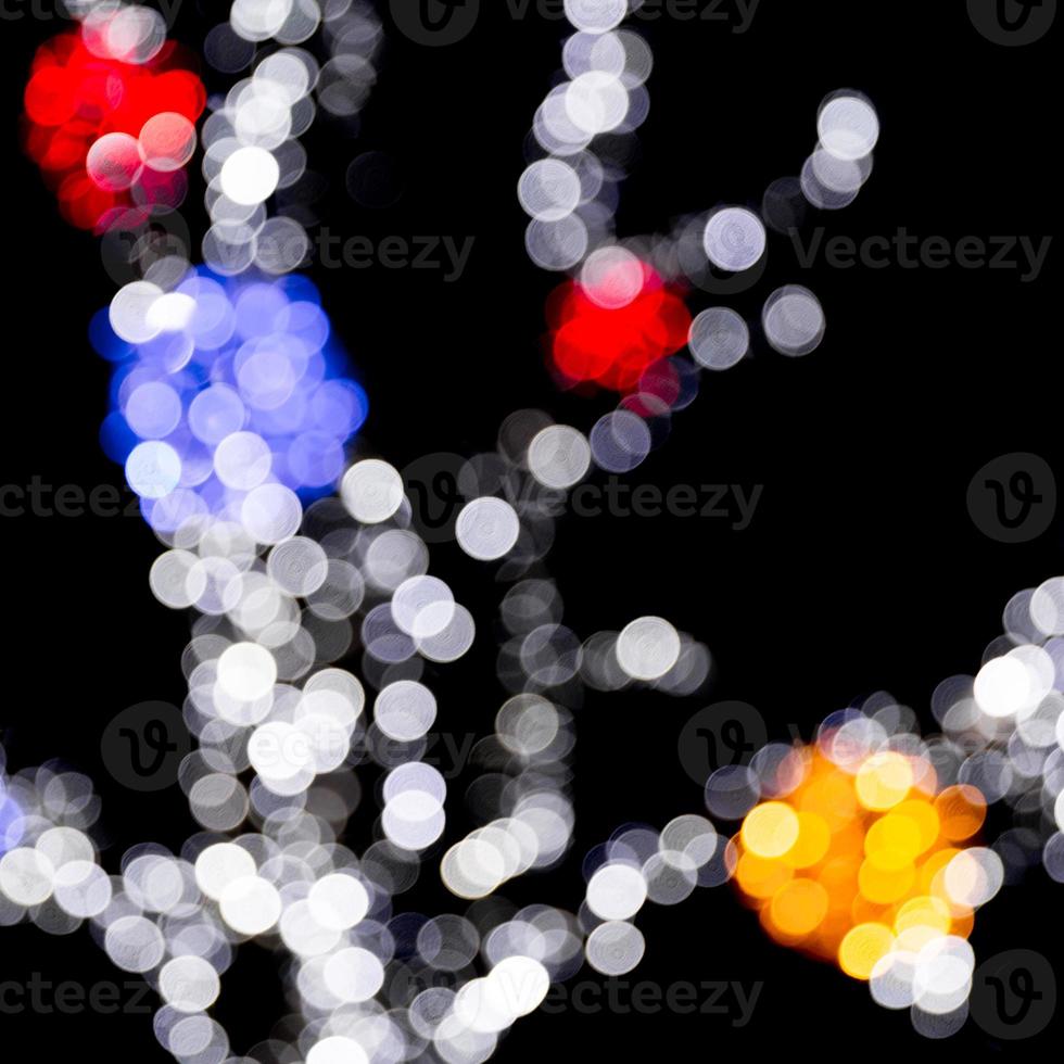 Unfocused abstract colourful bokeh with red, green, orange and blue lamp on black background. defocused and blurred many round light photo