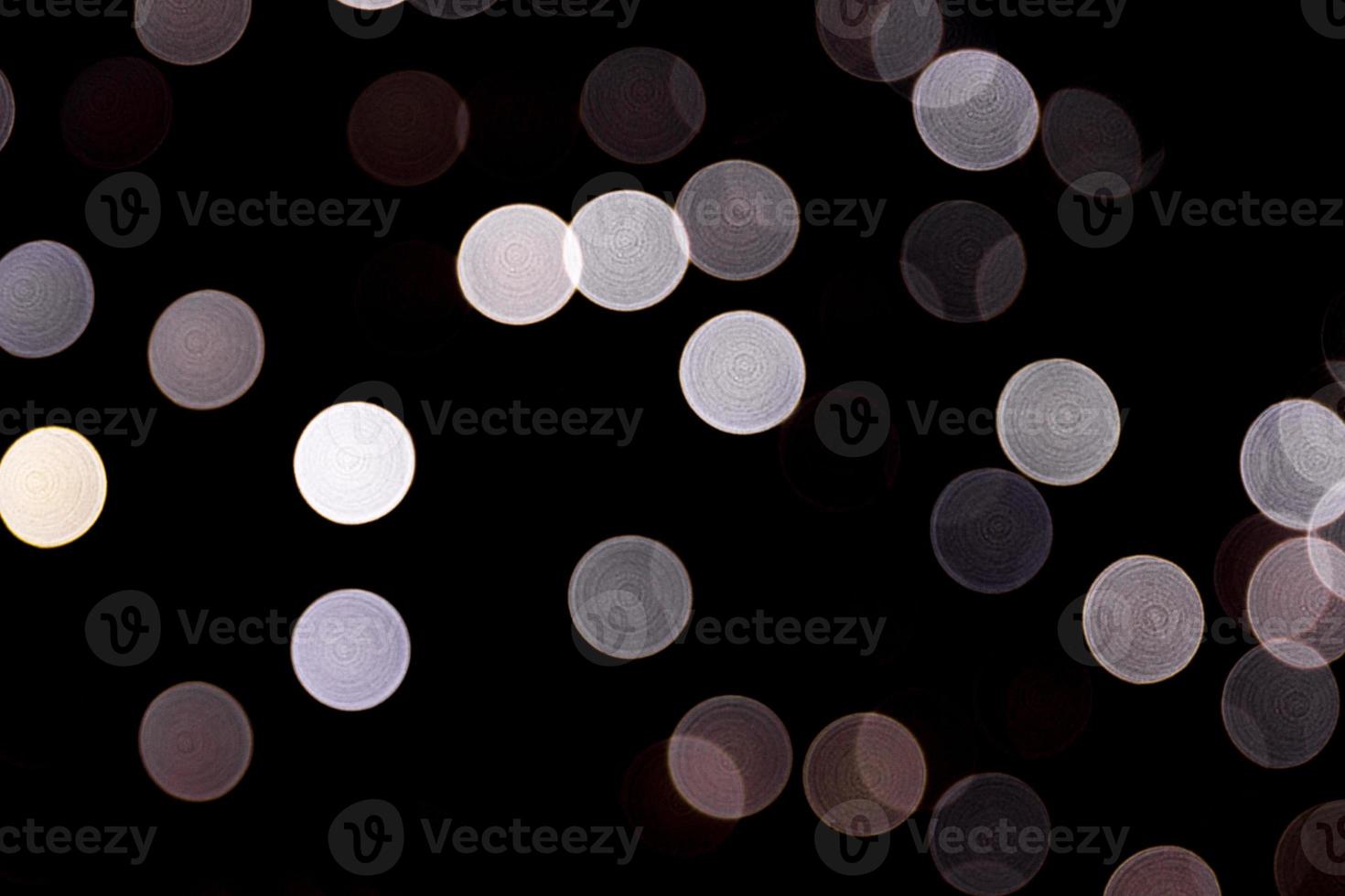 Abstract bokeh of white lights on black background. defocused and blurred many round light photo