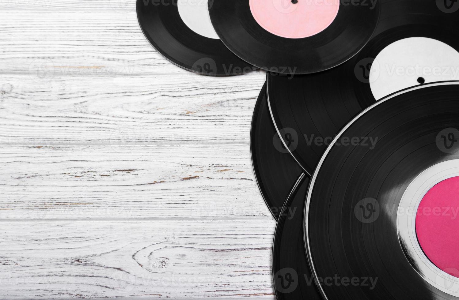 Old black vinyl records on white wooden background. vintage filtered. Copy space. Top view photo