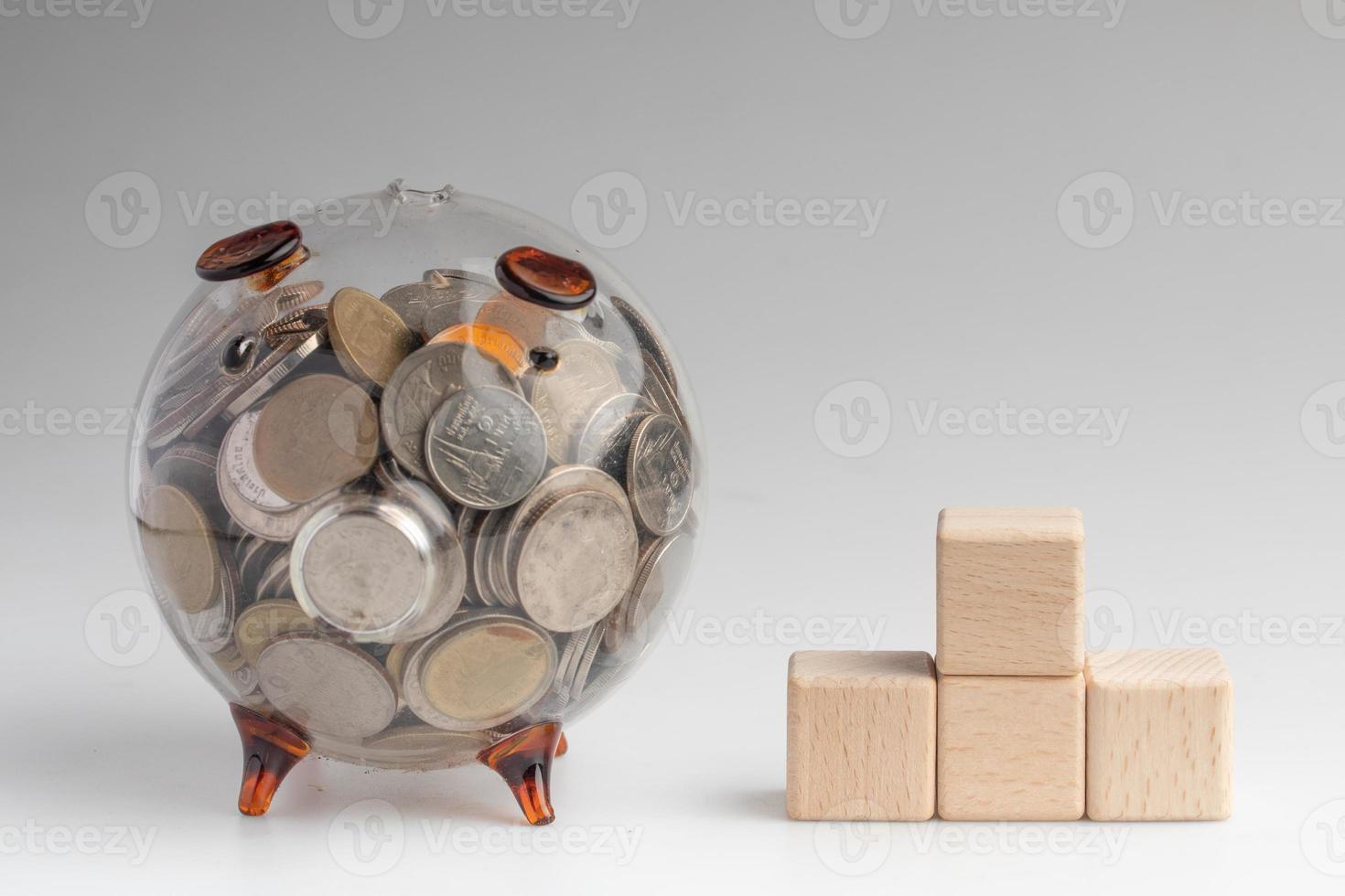 Transparent piggy bank with a wooden block for inserting messages photo