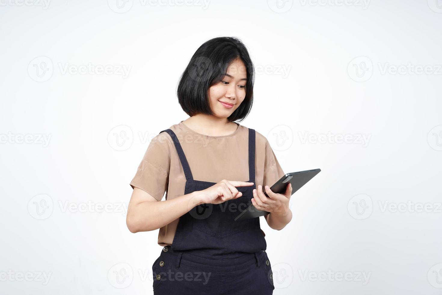 sosteniendo y usando una tableta de una hermosa mujer asiática aislada de fondo blanco foto
